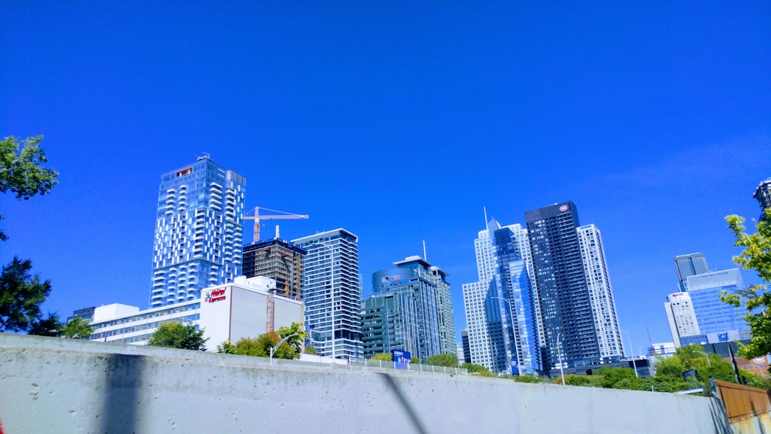 푸른 하늘 아래 고층 빌딩이 즐비한 도시 전경으로, 부동산 시장과 수도권 LTV·DSR 규제 강화를 상징함